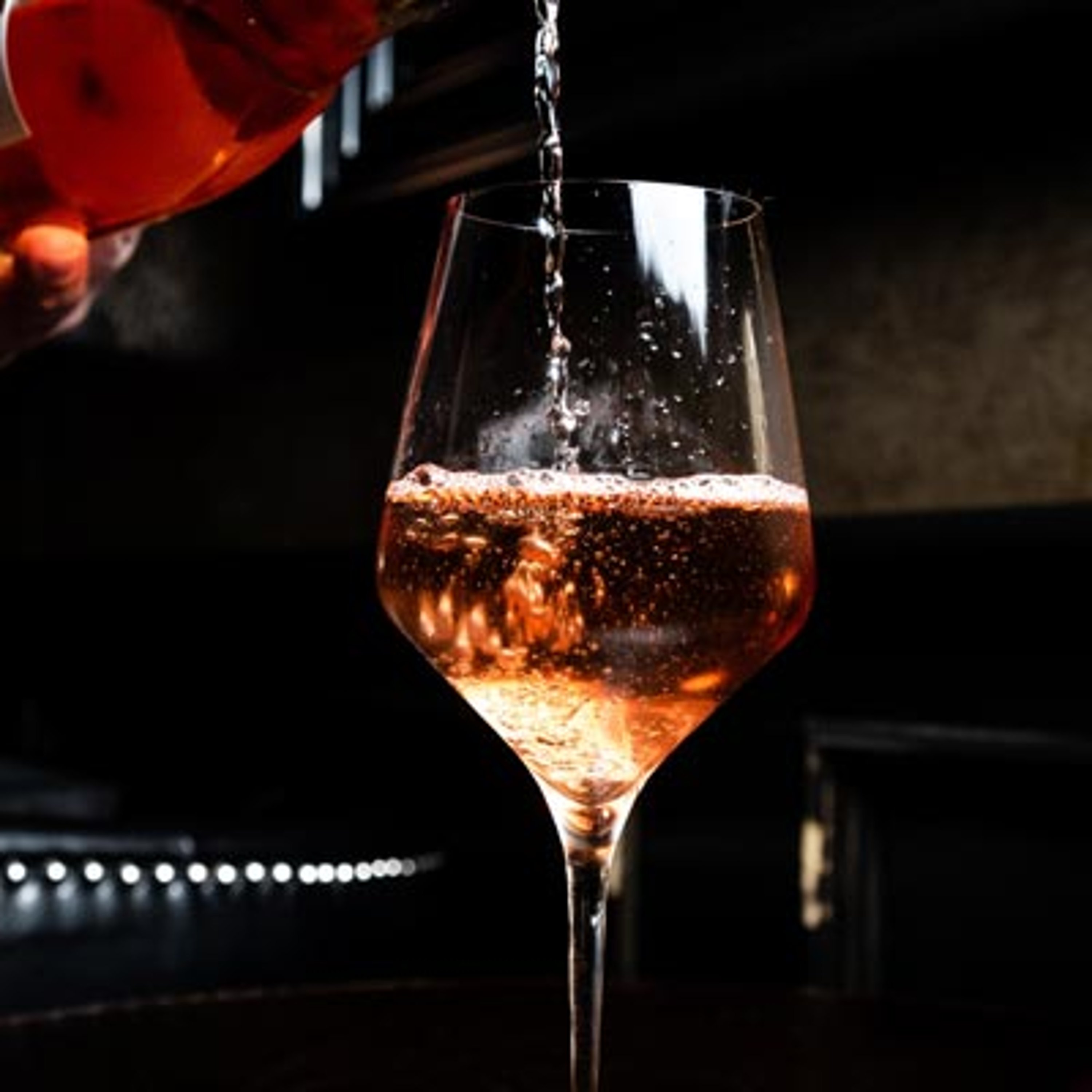 Rosé Champagner wird in Glas gefüllt